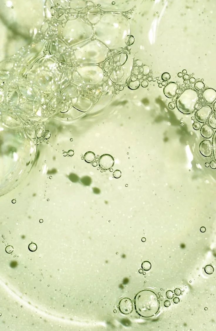 Pale green liquid with drifting bubbles, macro