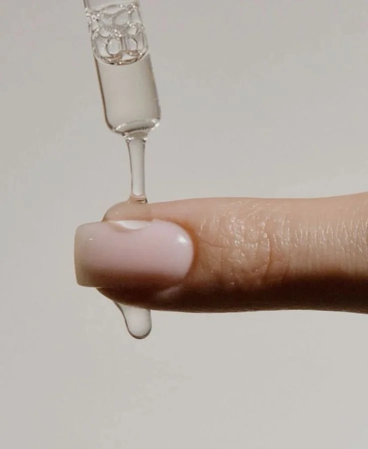 Glass dropper over a milky pearl nail